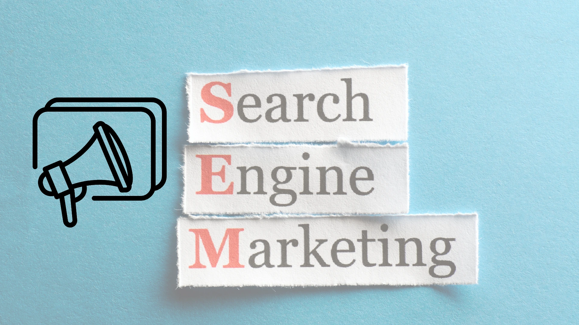 Pedazos de papel que forman la frase Search Engine Marketing con un fondo azul