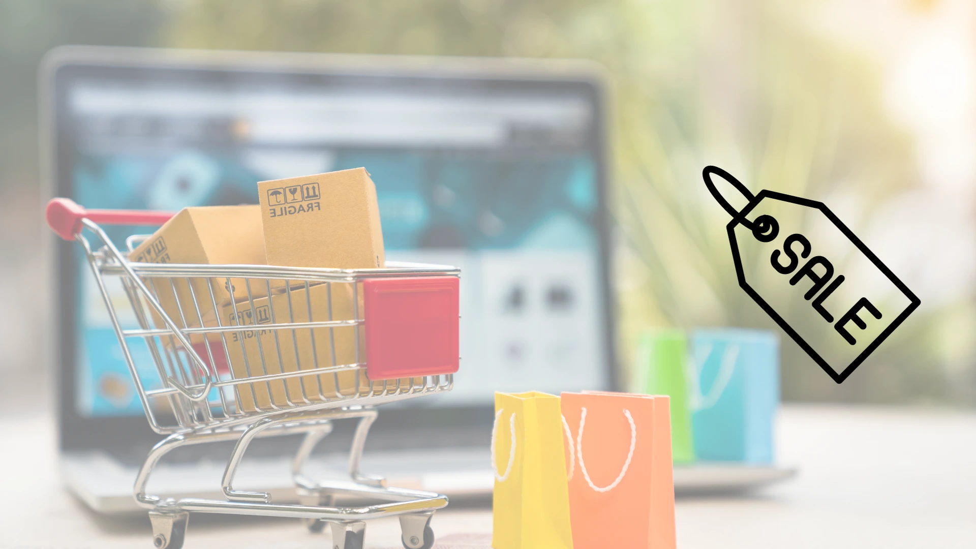 Laptop en una mesa y carrito pqueño de compras con cajas alusivas a productos 