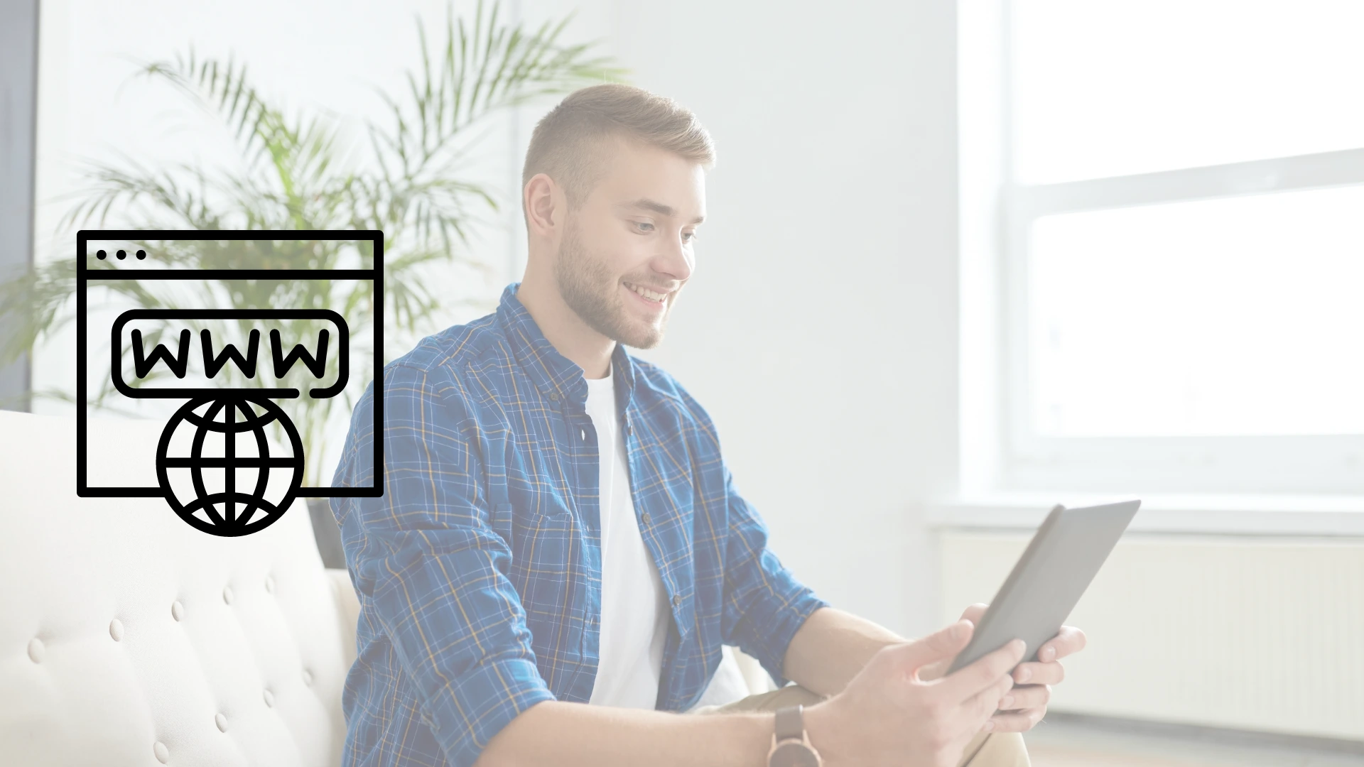 Joven sonriente sentado en una sala minimalista utilizando tablet