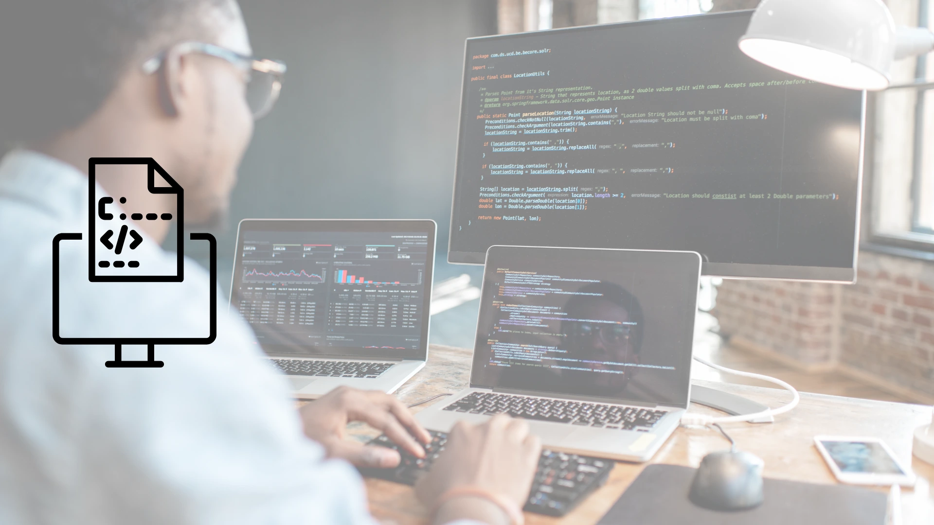 Hombre sonriente trabajando en varias computadoras en programación